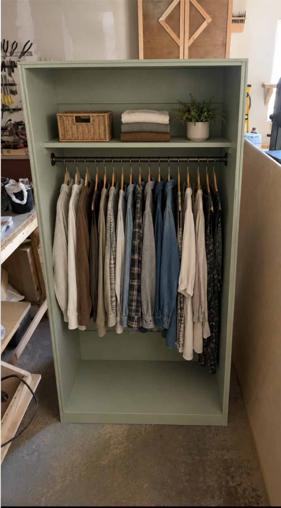 A sage green Alcove closet, with a shelf above a hanging rail of clothes